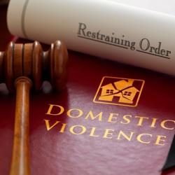 Domestic violence book, restraining order, and wooden gavel