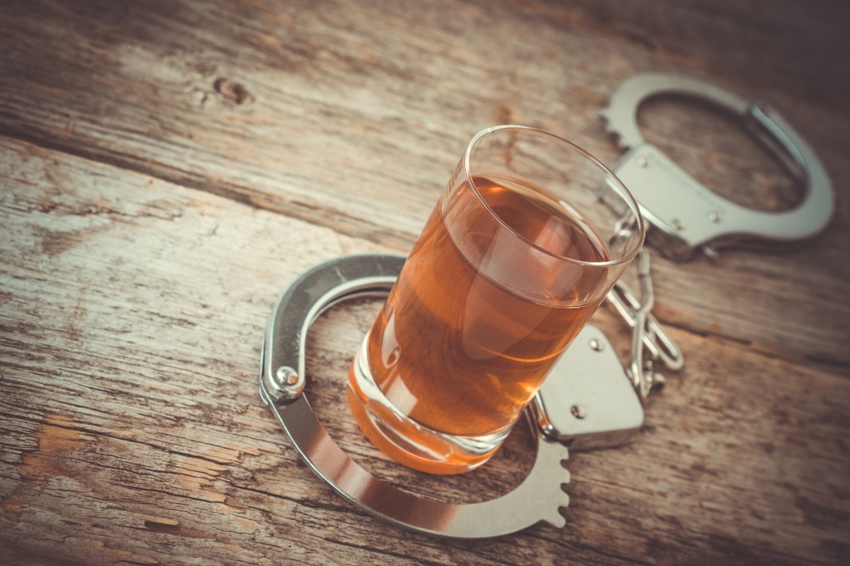 Alcoholic beverage and handcuffs on a table