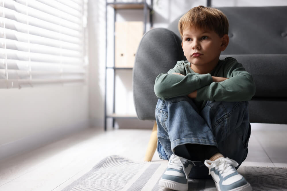 Sad child sitting alone at home, reflecting the impact of child endangerment charges on DCP&P investigations and custody cases in New Jersey.