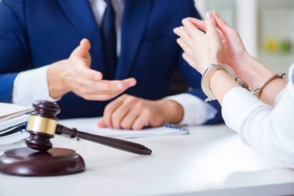 Monmouth County gun charge lawyer meeting with handcuffed client after arrest